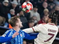 Serge Gnabry (Bayern) a Jurij Medveděv (Slovan)v súboji o loptu počas zápasu Ligy majstrov vo futbale Bayern Mníchov - Slovan Bratislava v Mníchove.