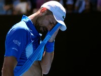 Novak Djokovic of Serbia wipes the sweat from his face during his semifinal match against Alexander Zverev of Germany at the Australian Open tennis championship in Melbourne, Australia, Friday, Jan. 24, 2025. (AP Photo/Asanka Brendon Ratnayake)