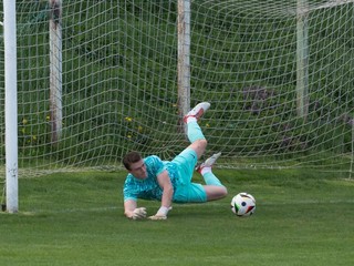 Brankár Nitrianskeho Rudna Šimon Báčik chytá pokutový kop Richarda Pagáča.