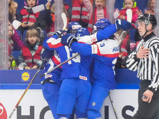 Slovenskí hokejisti sa radujú z gólu.