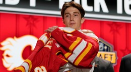 Samuel Honzek si oblieka dres Calgary Flames vo vstupnom drafte NHL 2023. 