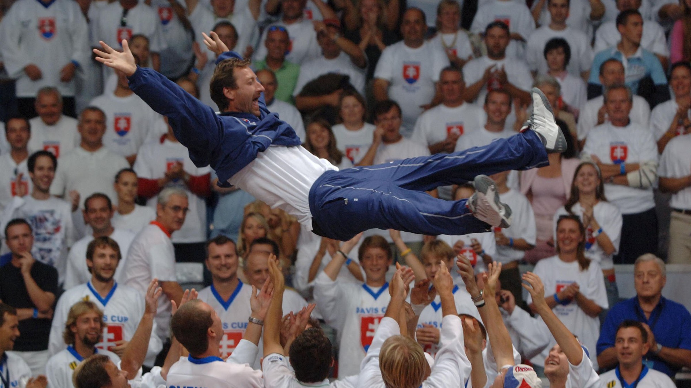 Miloslav Mečíř nad hlavami zverencov ako kapitán daviscupového tímu po výhre nad Argentínou v roku 2005.