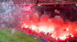 Fanúšikovia Ajaxu odpaľujú pyrotechniku.