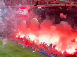 Fanúšikovia Ajaxu odpaľujú pyrotechniku.