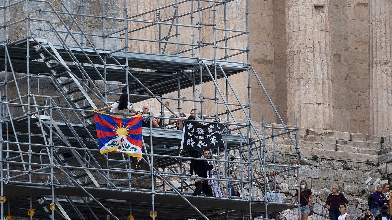 Protestujúci ľudia s vlajkou Tibetu.