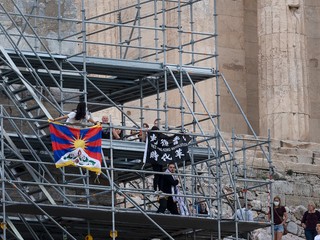 Protestujúci ľudia s vlajkou Tibetu.