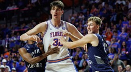 Na snímke basketbalista Floridy Olivier Rioux (uprostred) a hráči Severnej Floridy Dante Oliver (vľavo) a Nestor Dyachok (vpravo) počas zápasu univerzitnej basketbalovej ligy NCAA.