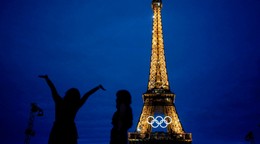 Nasvietená Eiffelova veža s olympijskými kruhmi večer pred slávnostným ceremoniálom na OH 2024.