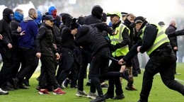 Usporiadatelia a policajti zasahujú počas bitky fanúšikov, ktorá sa strhla na ihrisku po penaltovom rozstrele po štvrťfinále Škótskeho pohára Rangers FC - Celtic Glasgow.