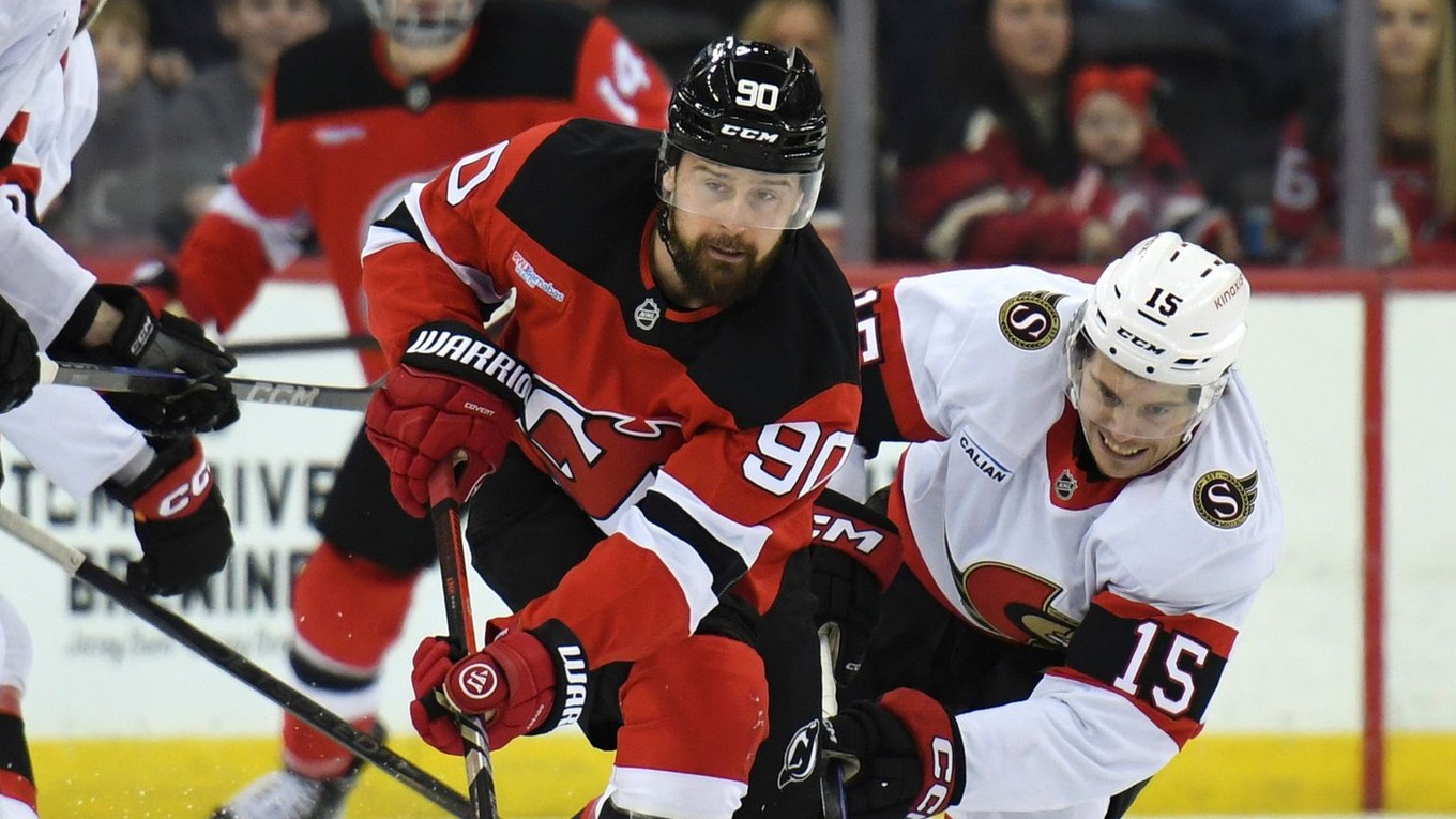 Tomáš Tatar (New Jersey) a Matthew Highmore (Ottawa) bojujú o puk.