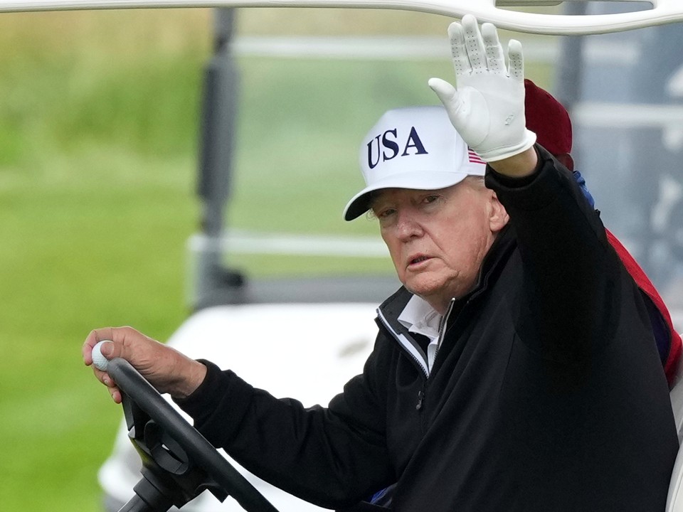 Donald Trump máva z golfového vozíka.