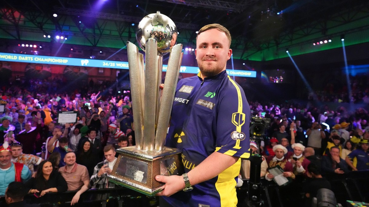 Angličan Luke Littler s trofejou Sida Waddella pre víťaza MS v šípkach. 