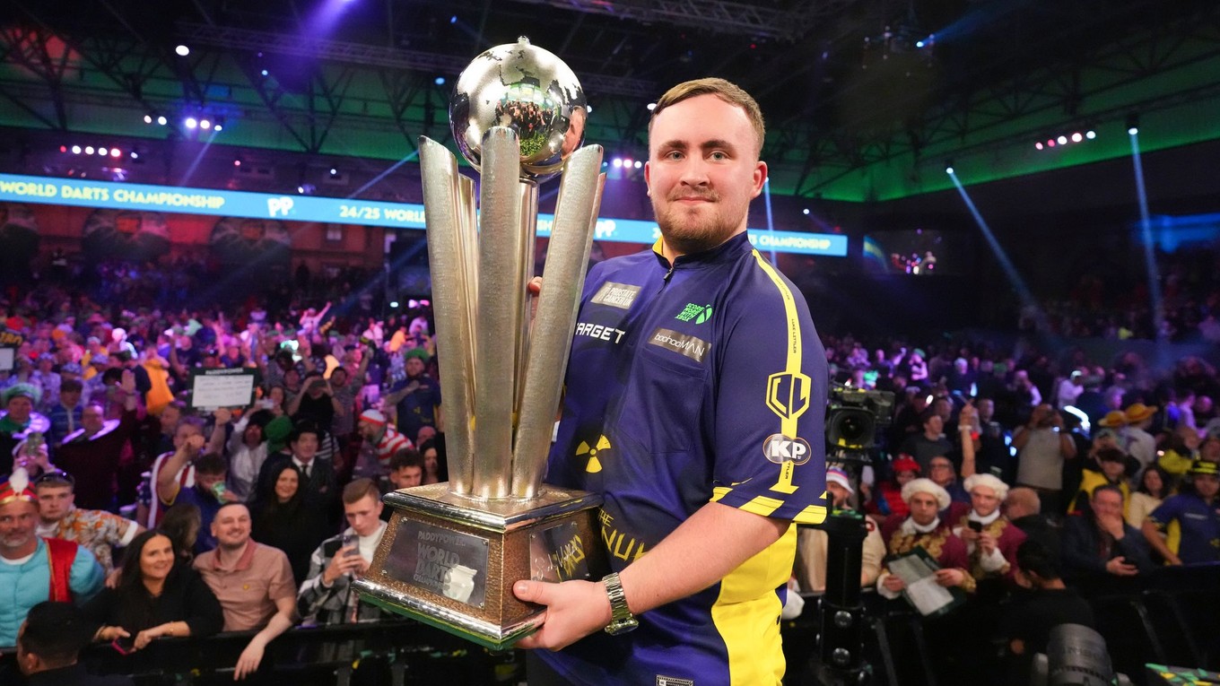 Angličan Luke Littler s trofejou Sida Waddella pre víťaza MS v šípkach. 