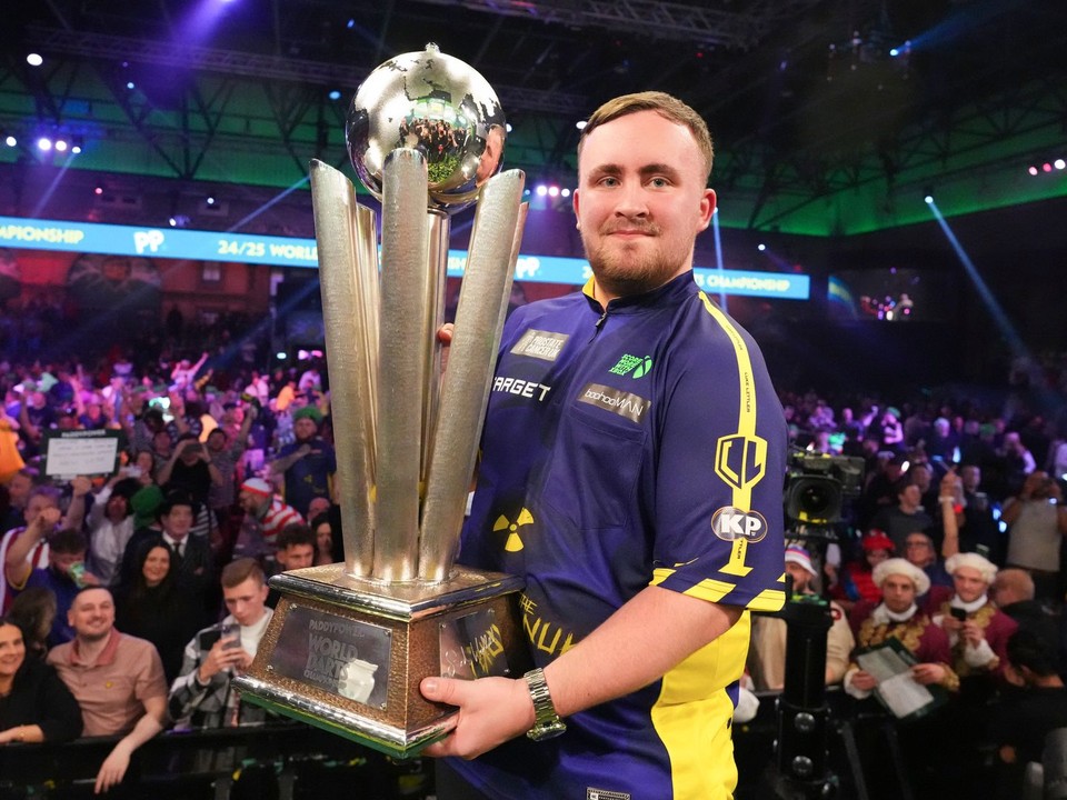 Angličan Luke Littler s trofejou Sida Waddella pre víťaza MS v šípkach. 