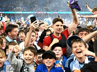 Brankár Slovana Dominik Takáč (červený dres) sa teší s divákmi zo zisku rekordného 15. titulu v najvyššej slovenskej futbalovej súťaži.