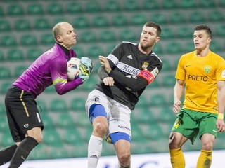 Brankár Žiliny Miloš Volešák zasahuje pred dotierajúcim hráčom Dunajskej Stredy.