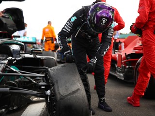 Lewis Hamilton si obzerá zničenú pneumatiku.