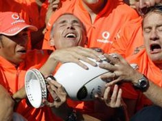 Víťaz VC Maďarska Lewis Hamilton (vľavo) a šéf tímu McLaren Mercedes Martin Whitmarsh (uprostred) s trofejou pre víťaza.