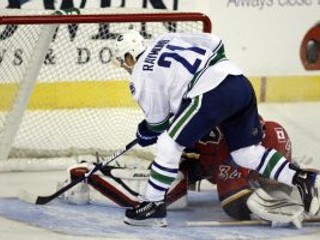 Mason Raymond z Vancouveru strieľa víťazný gól do brány Miikku Kiprusoffa (Calgary).