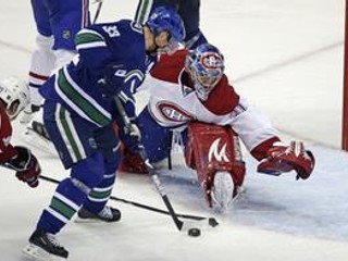Henrik Sedin (vpravo) dáva gól brankárovi Montrealu Careymu Priceovi.