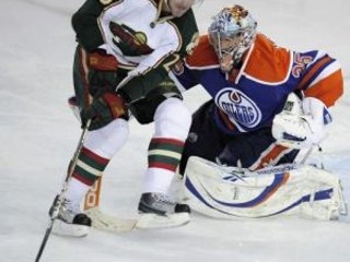 Eric Belanger (25, Minnesota Wild) sa pokúša prekonať brankára Edmontonu Oilers Nikolaja Chabibilina.