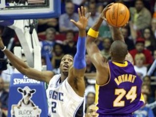 Hviezdsa LA Lakers Kobe Bryant (24) zakončuje cez Dwighta Howarda z Orlanda Magic.