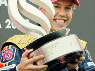 Jazdec s detskou tvárou Sebastian Vettel z tímu Toro Rosso s trofejou na zmoknutej VC Talianska. V 32. pretekoch kariéry vybojoval prvé víťazstvo.