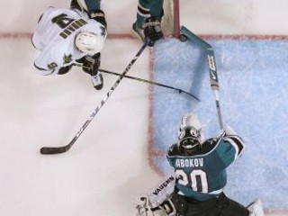 Brankár San Jose Sharks Jevgenij Nabokov zabraňuje pokusu hviezdy Dallas Stars Mike Modana (9). Na snímke je ešte spuluhráč kazašského gólmana Jeremy Roenick (27).