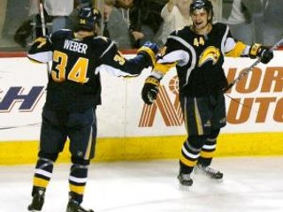 Andrej Sekera oslavuje so spoluhráčom Mikom Weberom svoj víťazný gól proti Bostonu Bruins
