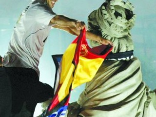 Kapitán Raúl oblieka sochu Cibeles do klubového šálu a španielskej vlajky.