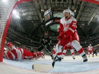 Obranca Detroitu Brad Stuart a brankár Chris Osgood zabránili puku v smerovaní do brány.