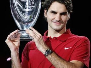 Roger Federer pózuje fotografom s víťaznou trofejou.