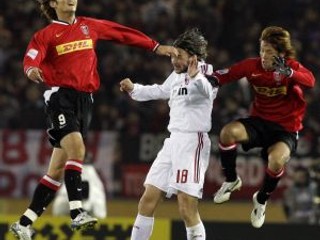 Obranca milánskeho AC Marek Jankulovski (v bielom) v súboji s dvojicou hráčov Urawy počas semifinálového stretnutia MS klubov.