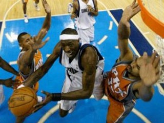 Josh Howard (v bielom) z Dallasu Mavericks sa snaží zakončiť cez hráča Phoenixu Borisa Diawa.