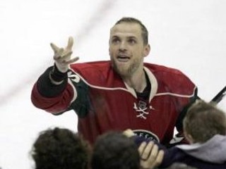 Marián Gáborík v strede oslavovaný spoluhráčmi Keithom Carneyom (vľavo) a Seanom Hillom po skórovaní piateho gólu  v zápase proti New York Rangers .