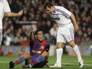 Ronaldinho z Barcelony (na zemi) sa škriepi s Fabiom Cannavarom z Realu. Madridčania vyhrali v Barcelone 1:0, sledovalo 98 248 divákov.