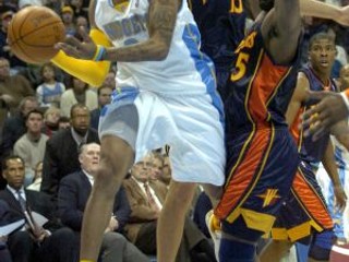 Hviezda Denveru Alan Iverson (v bielom) preniká cez dvojicu Baron Davis (č. 5) - Andris Biedrins (Golden State).