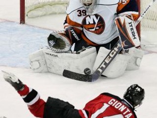 Brankár New York Islanders Rick DiPietro (39) zasahuje po pokuse hráča New Jersey Devils Briana Giontu (14).
