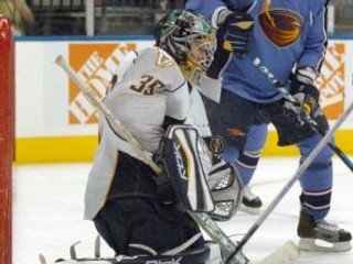 Brankár Nashville Dan Ellis odráža strelu pred slovenským hráčom Atlanty Mariánom Hossom v prípravnom zápase NHL v Atlante 25.septembra 2007