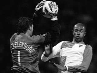 Brankár Ajaxu Amsterdam Maarten Stekelenburg zachraňuje pred brazílskym obrancom Werderu Brémy Naldom. Nemecký tím vyhral v prvom zápase šestnásťfinále Pohára UEFA 3:0 a pred dnešnou odvetou v Holandsku má všetko vo svojich rukách.