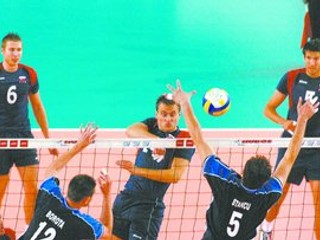 Slovensko cez víkend porazilo v Európskej lige dvakrát Rumunsko. Záber je zo sobotňajšieho zápasu. Cez Rumuna Stancua smečuje Tomáš Kmeť. Prizerajú sa Róbert Hupka (č. 6) a Július Šabo (5).