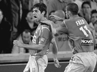 Brazílsky režisér hry Lyono Juninho (vľavo) sa spolu so svojím spoluhráčom Fredom teší z gólu do siete Marseille.