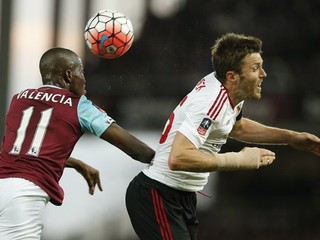 Na snímke vpravo hráč United Michael Carrick a vľavo hráč West Hamu Enner Valencia.