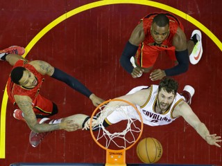 Kevin Love z Clevelandu (v bielom) bojuje o loptu vo výskoku s dvojicou hráčov Atlanty - Kentom Bazemorem (vľavo) a Paulom Millsapom.