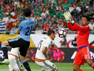 Mexický gólman Alfredo Talavera likviduje hlavičkové zakončenie uruguajského kanoniera Edinsona Cavaniho.