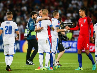 Futbalisti Slovenska a Anglicka sa po zápase objímajú a podávajú si ruky.
