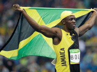 Usain Bolt s národnou vlajkou oslavuje svoje ďalšie olympijské zlato.