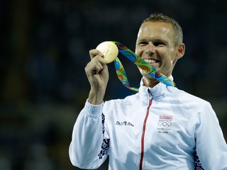 Matej Tóth pózuje so zlatou olympijskou medailou.