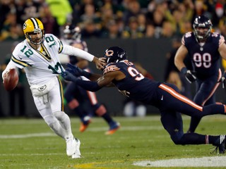 Hviezdneho quarterbacka tímu Green Bay Packers Aarona Rodgersa (vľavo) sa pokúša zložiť na zem hráč Chicaga Bears Leonard Floyd.