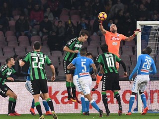 Brankár Neapolu Pepe Reina boxuje loptu v zápase proti Sassuolu.